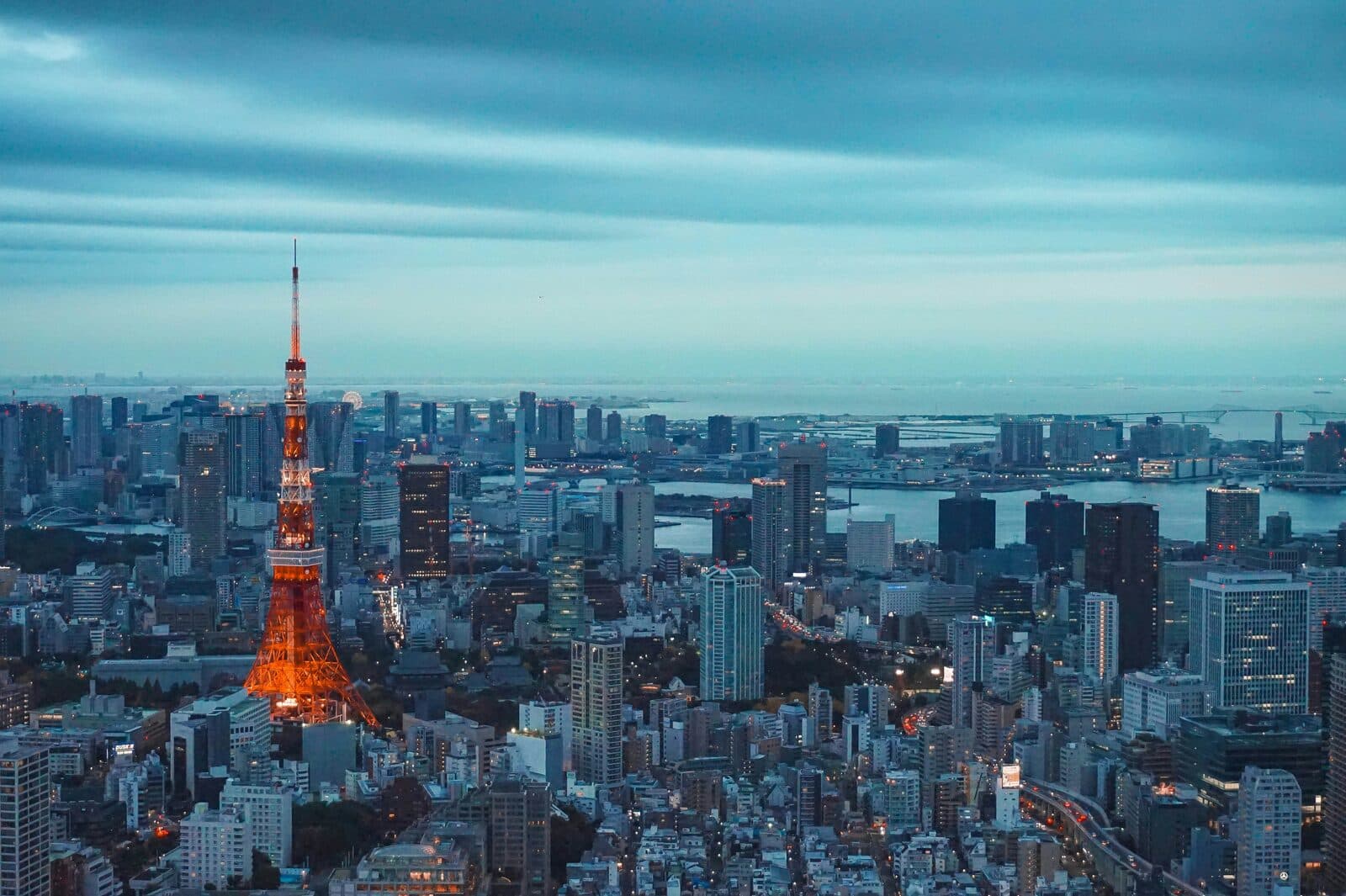 Aerial view of the Tokyo skyline with Tokyo Tower lit orange at dusk